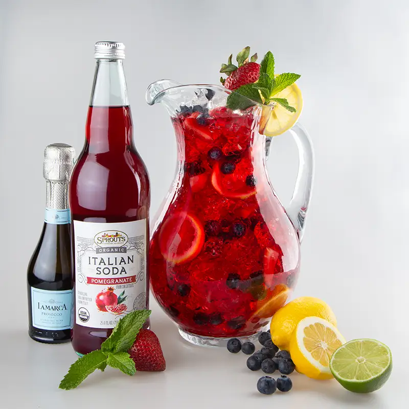 Berry spritzer ingredients next to a glass pitcher